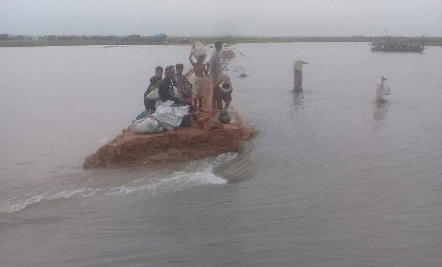 এবার গোমস্তাপুরের বাঁধ ভেঙে সড়ক যোগাযোগ বিছিন্ন ঃআটকা পড়েছে ধান বোঝাই যান